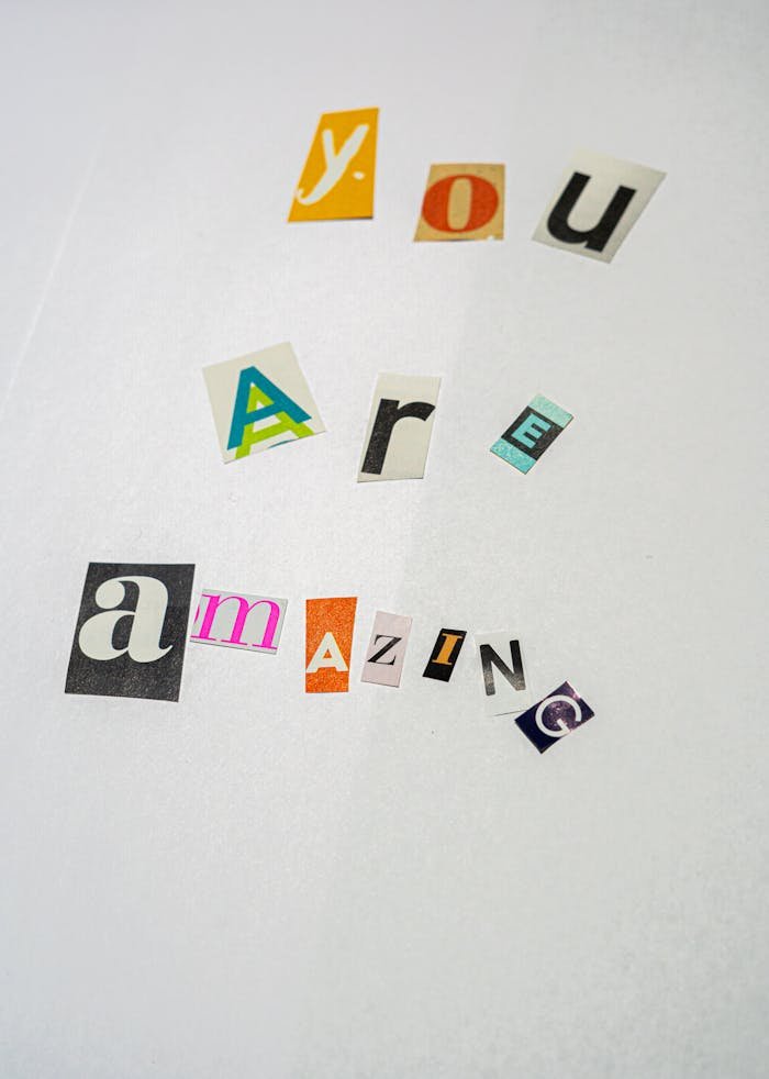Creative cutout letters forming 'You Are Amazing' on white paper, offering motivation.